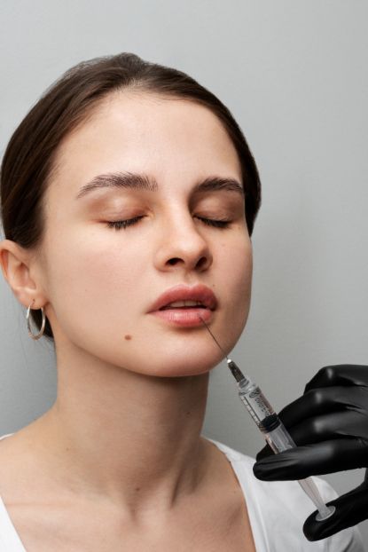 Beautiful woman getting lip fillers at clinic